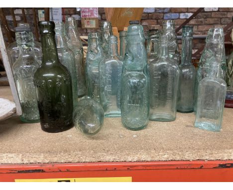 A LARGE QUANTITY OF VINTAGE GLASS BOTTLES WITH EMBOSSESD MAKERS NAMES, SOME WITH STOPPERS 
