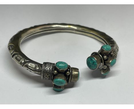 A WHITE METAL NAVAJO BANGLE WITH STONES 