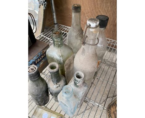 AN ASSORTMENT OF VINTAGE GLASS BOTTLES WITH MOST BEARING VARIOUS NAMES 