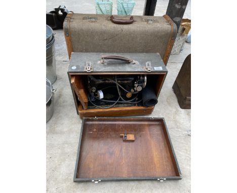 A CASED VINTAGE SINGER SEWING MACHINE AND A VINTAGE SUITCASE 