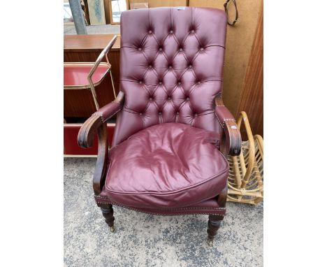 A VICTORIAN STYLE MAHOGANY BUTTON-BACK LOUNGE CHAIR ON TURNED FRONT LEGS WITH BRASS CASTERS 