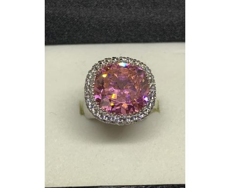 A SILVER RING WITH A LARGE PINK STONE SURROUNDED BY CLEAR STONES SIZE L IN A PRESENTATION BOX 