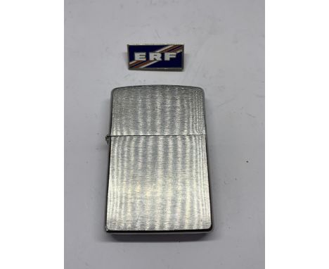 A MADE IN USA ZIPPO LIGHTER AND AN ENAMEL ERF BADGE 