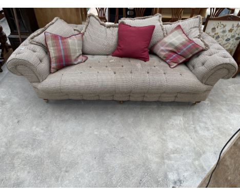 A TWEED UPHOLSTERED BUTTON BACK CHESTERFIELD TYPE THREE SEATER SOFA ON BRASS CASTOR SUPPORTS 