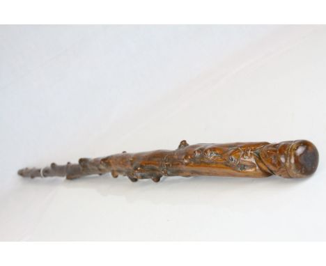 A 19th century antique folk art walking stick the handle in the form of man in cap the stem carved with styalised animals and