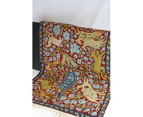 A small woven rug decorated with stylised cats possibly tigers hunting deer and goats in a jungle setting.