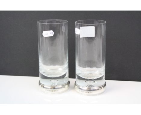 A pair of drinks glasses with fully hallmarked sterling silver bands to the base.