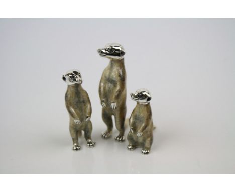 A collection of three enamel and hallmarked silver meerkat figures.