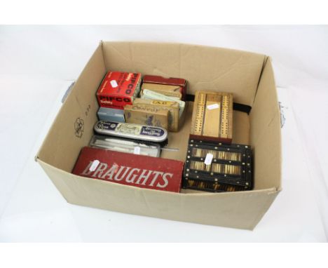 Box of mixed collectables to include a small collection of coins, playing cards, cribbage boards and a set of draughts.
