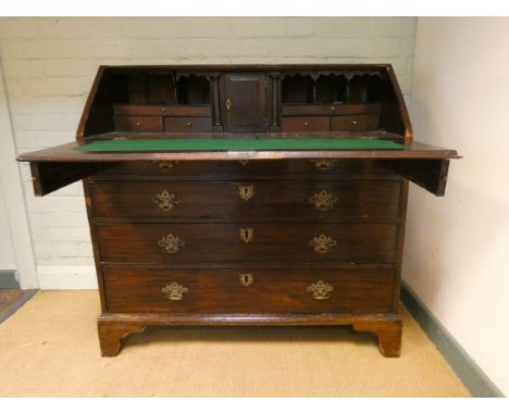 A Georgian mahogany bureau with fitted interior and four long drawers under, standing on bracket feet 