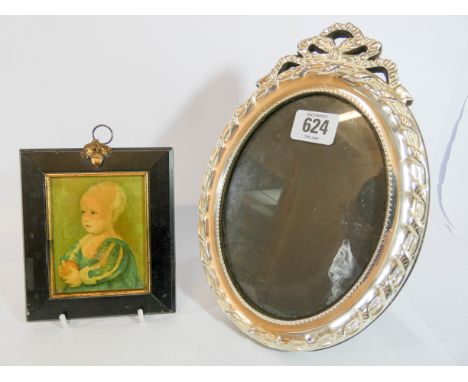 A oval decorative white metal photograph frame and a small portrait miniature in a rectangular ebonised frame