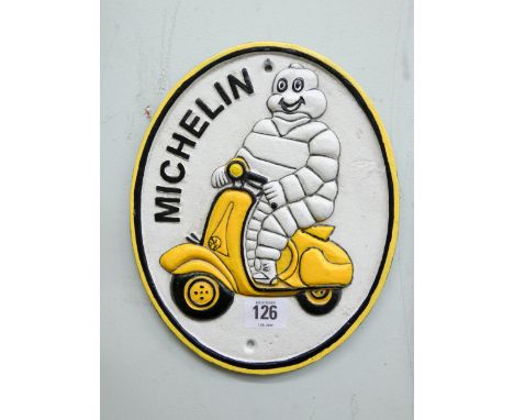 A cast iron oval Michelin Man on a scooter 