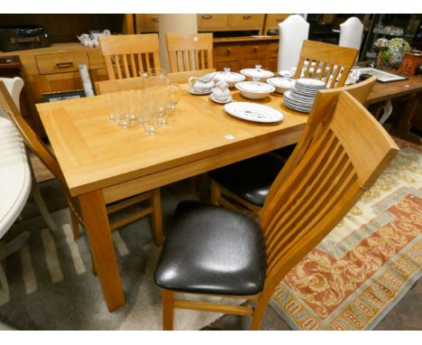 A good quality heavy light oak extending dining table with two extra leaves, together with six matching spindle back chairs w