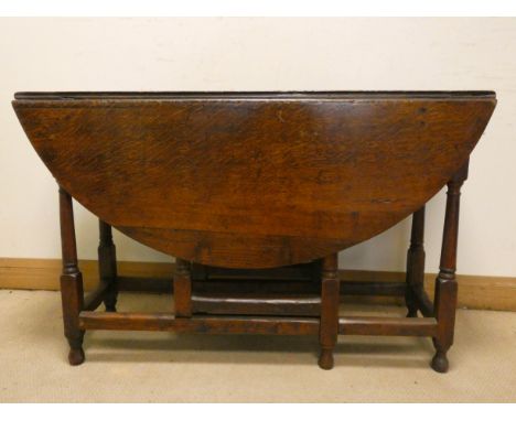 An antique style circular oak gate legged table on turned legs, 4' wide 