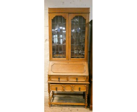A 1930's light oak leaded glazed bureau bookcase, standing on barley twist legs, 3' wide 
