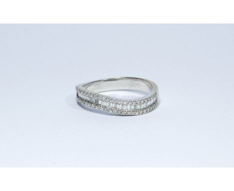 An 18ct white gold band ring set with baguette and brilliant cut diamonds in a wave design, ring size R, approximate weight 4