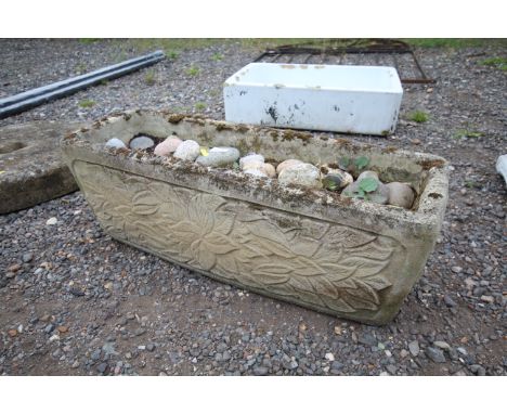 A concrete garden planter decorated with foliage