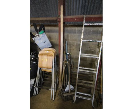 A quantity of long handled garden tools to include forks, brushes, rakes, hoes etc