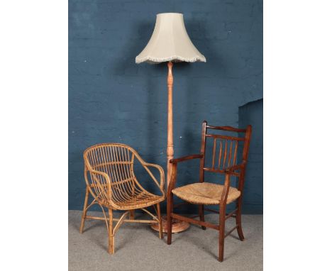 A rush seat arm chair along with a bamboo chair and a standard lamp.  