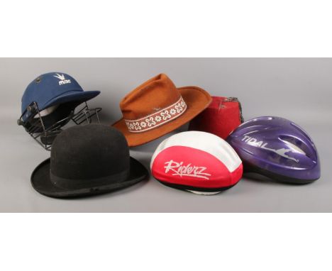 A collection of assorted hats. To include a Dunn &amp; Co bowler hat, two bicycle hats, cricket helmet etc  