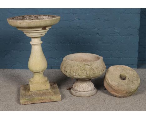 A three piece garden birdbath, together with a grindstone and garden planter. Height of birdbath: 72cm.  