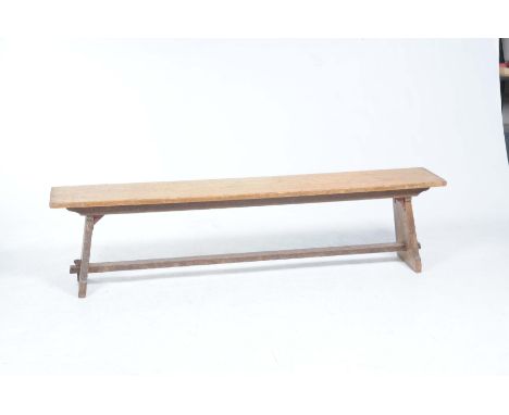 A rustic ash bench
The rectangular top supported on out swept bracket supports with a plain cross stretcher 183x46x32cm 