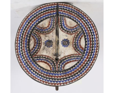 second half of the 20th century, of circular carved and pigmented form, carved with rows of jagged designs together with a pa