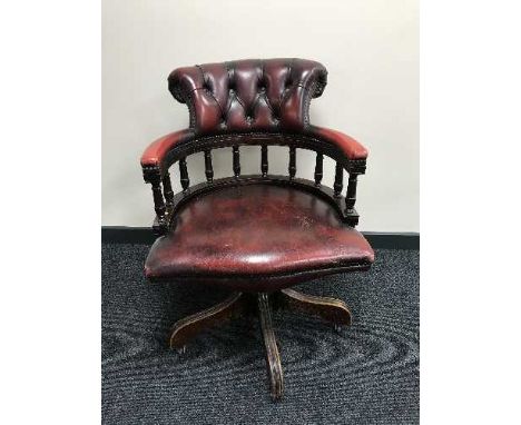 A red button leather Chesterfield swivel armchair 