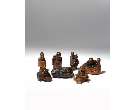 SIX JAPANESE WOOD NETSUKE AND ONE UMIMATSU MEIJI PERIOD, 19TH CENTURY Variously carved as deities, two depicting Hotei, two D