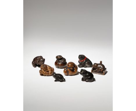 EIGHT JAPANESE WOOD NETSUKE OF DOGS MEIJI PERIOD, 19TH CENTURY Depicted in a variety of positions, one with a red ribbon atta