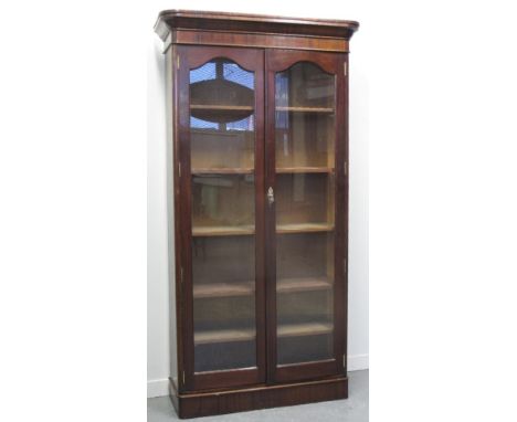 EARLY 20TH CENTURY MAHOGANY TWO DOOR GLAZED BOOKCASE, having moulded cornice over two glazed, arch panel doors revealing five