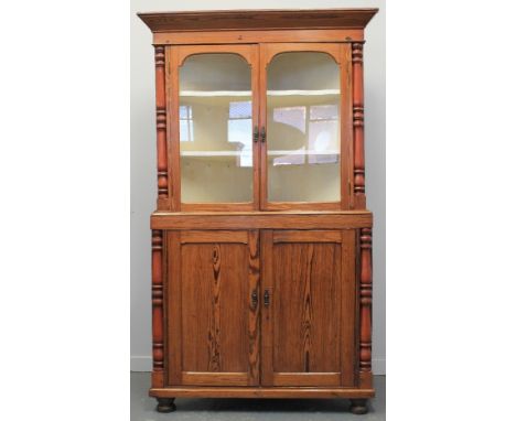 LATE 19TH CENTURY WELSH PITCH PINE CORNER CABINET, having angled cornice over a pair of arch glazed doors revealing two fitte