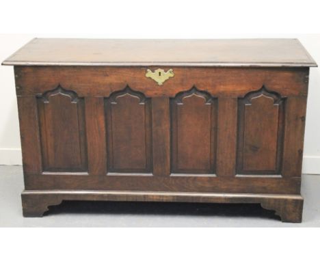 18TH CENTURY WELSH OAK COFFER, having hinged moulded edge top over four ogee pointed arch panels to the front standing on bra