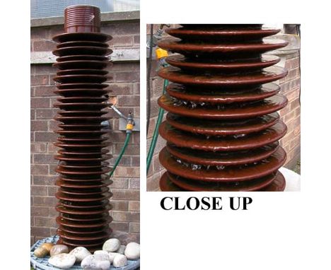 *CERAMIC ELECTRICITY INSULATOR, SET UP AS A WATER FEATURE, LATE 1900S. HEIGHT 1240MM (48IN) X WIDTH 230MM (9IN) [0]