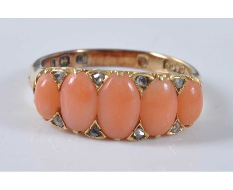 A yellow metal coral half hoop eternity ring, comprising five oval pink coral cabochons with eight rose cut diamond points, a