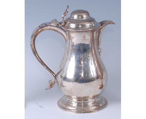An early George III silver wine or beer jug, having a hinged domed cover, S-scroll handle, and raised on domed foot, 24oz, ma