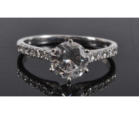 A white metal diamond solitaire ring, comprising a centre round brilliant cut diamond in a six-claw setting, with six melee c