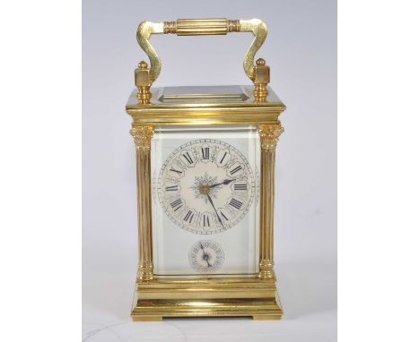 A circa 1900 lacquered brass carriage clock, having three-quarter turned pilasters flanking white enamel dial with subsidiary