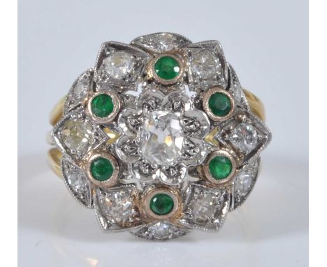 A yellow and white metal, emerald and diamond circular cluster ring, featuring a centre old cushion cut diamond within a bord