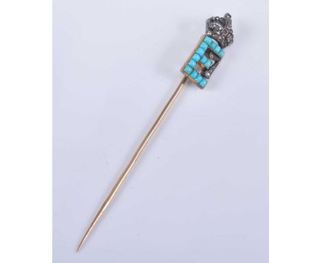 A yellow metal royal monogram stick pin, depicting the initial E set with fourteen 1.6 x 1.3mm rectangular turquoise surmount