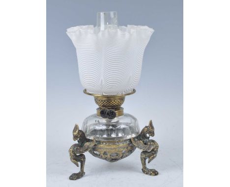 A Victorian brass oil lamp, having a white and frosted Verre Moire silk glass shade above a cut glass font, standing upon thr
