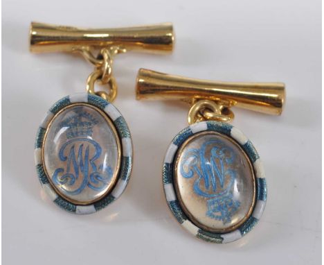 A pair of yellow metal reverse crystal cufflinks, each featuring the Royal monogram M surmounted by a crown with blue and whi