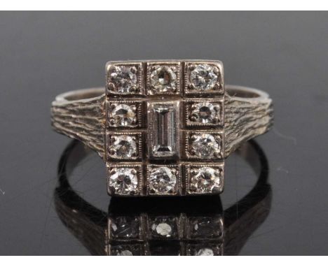 A white metal diamond rectangular cluster ring, comprising a centre baguette cut diamond within border of ten single and roun