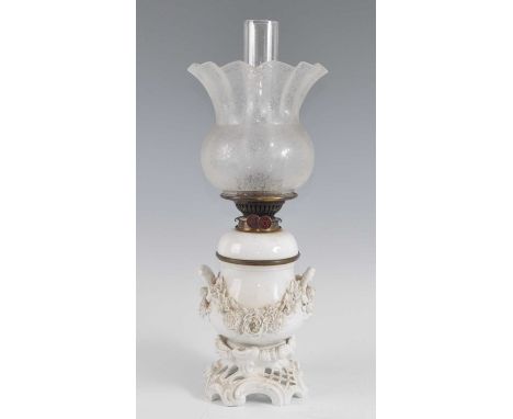 A 19th century blanc de chine porcelain oil lamp, the acid etched shade above a floral encrusted body flanked by twin loop ha