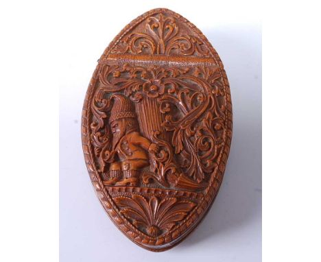 A late 19th century Norweigan treen souvenir snuff box, of elongated oval form, intricately carved with scrolling flora and a