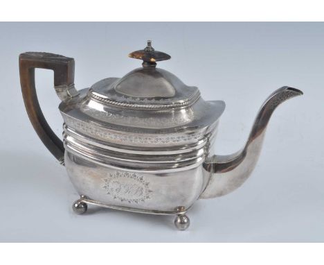 A George III silver teapot, of shaped rectangular form with banded decoration, walnut handle and finial, standing on four bal