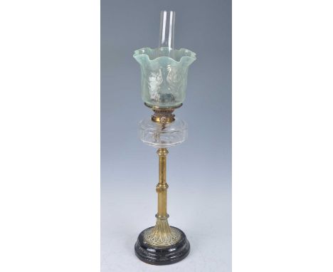 A Victorian brass oil lamp, having a vaseline glass shade and clear cut glass font above a plain adjustable column and black 