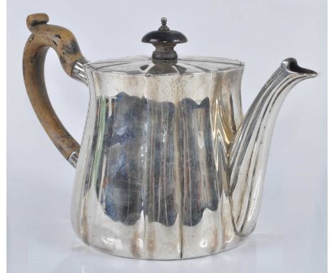 A George V silver teapot, of fluted lightly tapering circular form, having hinged fluted flat rim, with ebonised finial and h