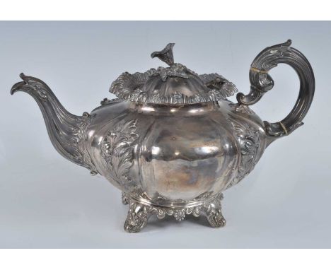 A William IV silver teapot, of fluted melon form with acanthus leaf decoration and flower head finial, standing on four shell