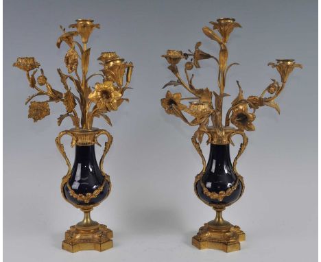 A pair of mid-19th century gilt metal and porcelain four-light candelabra, each naturalistically fashioned as flowers and fol